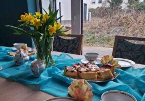 Gedeckter Tisch mit Blumen und Kuchen