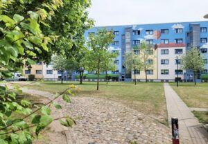 Wohngebäude mit bemalter Fassade und parkähnlicher Umgebung