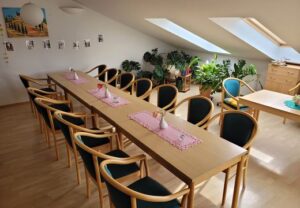 Konferenzraum mit langen Tischen und Sitzgelegenheiten