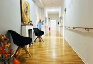 Innenansicht eines gepflegten Flurs mit Holzfußboden und Herbstdekoration.