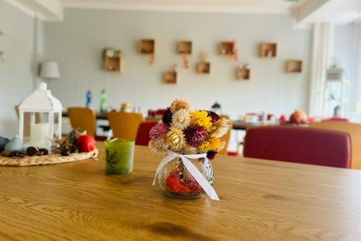 Ein geschmückter Tisch in einem hellen Raum mit einem Blumenarrangement.