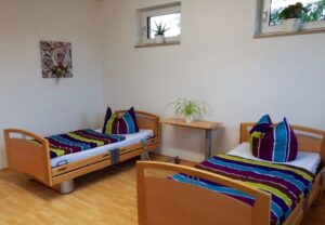 Ein gemütliches Zimmer mit zwei Einzelbetten, die bunt gestreifte Bettwäsche haben.