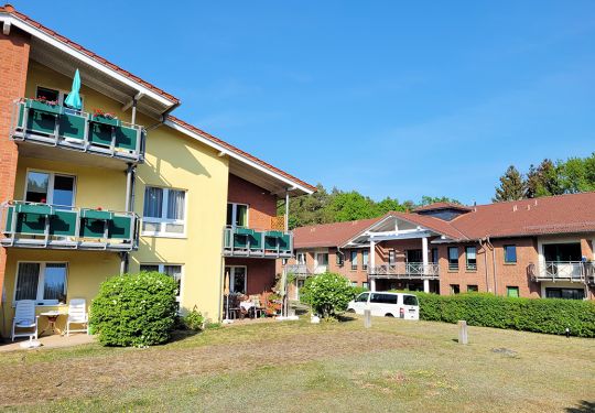 Außenansicht eines Gebäudes mit Balkonen und gepflegtem Außenbereich