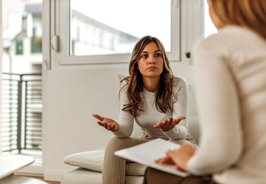 Zwei Frauen im Gespräch in einem gemütlichen Raum