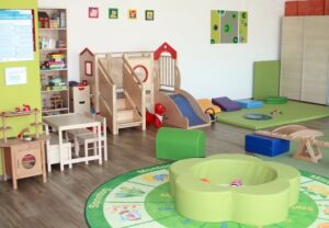 Innenansicht eines Spielzimmers mit Spielgeräten und bunten Elementen.