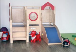 Spielbereich für Kinder mit Holzrutsche und Spielzeug
