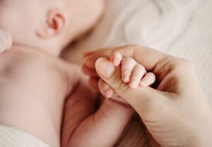Ein Erwachsener hält die Hand eines Babys