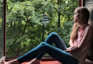 Frau sitzt nachdenklich am Fenster