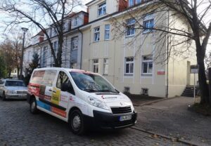 Transporter vor einem Gebäude geparkt