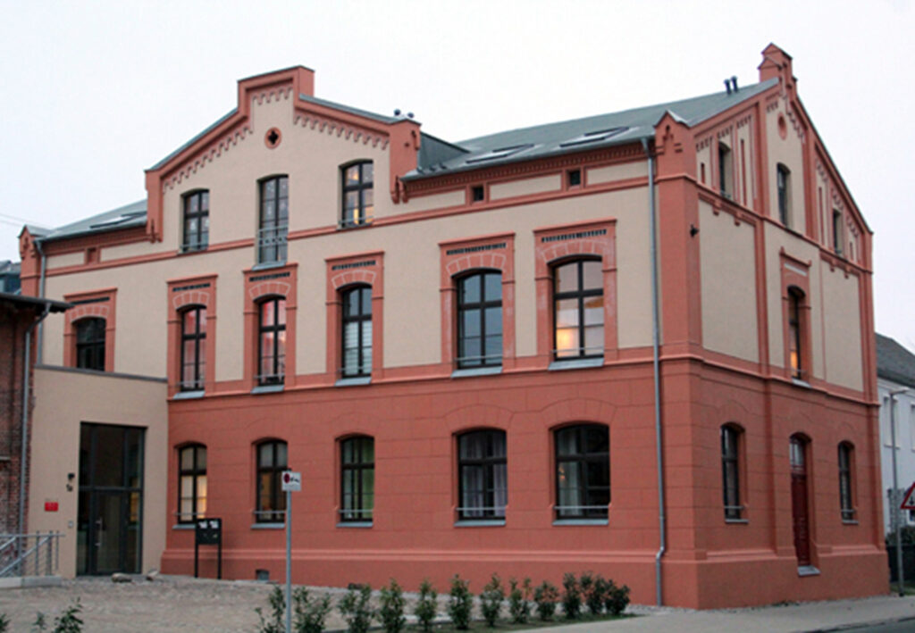 Gebäude der AWO mit rötlicher Fassade und großen Fenstern