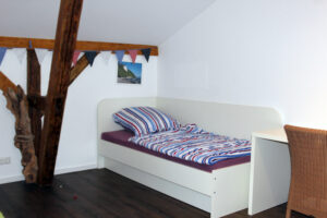 Ein schlicht eingerichtetes Schlafzimmer mit Einzelbett.