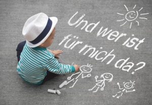 Kind sitzt auf Asphalt mit Kreidezeichnung und Text