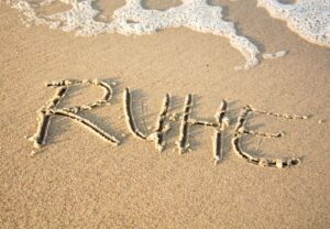 Das Wort 'RUHE' im Sand am Strand geschrieben