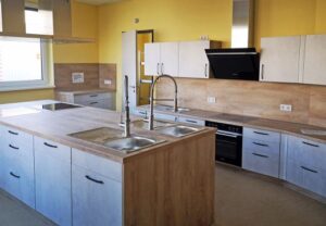 Moderne Küche mit L-förmiger Arbeitsplatte und gelben Wänden