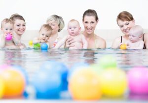 Gruppe von Erwachsenen und Babys beim Schwimmen
