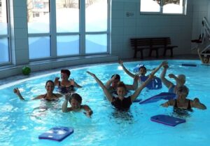Gruppe von Menschen beim Aquafitness im Hallenbad