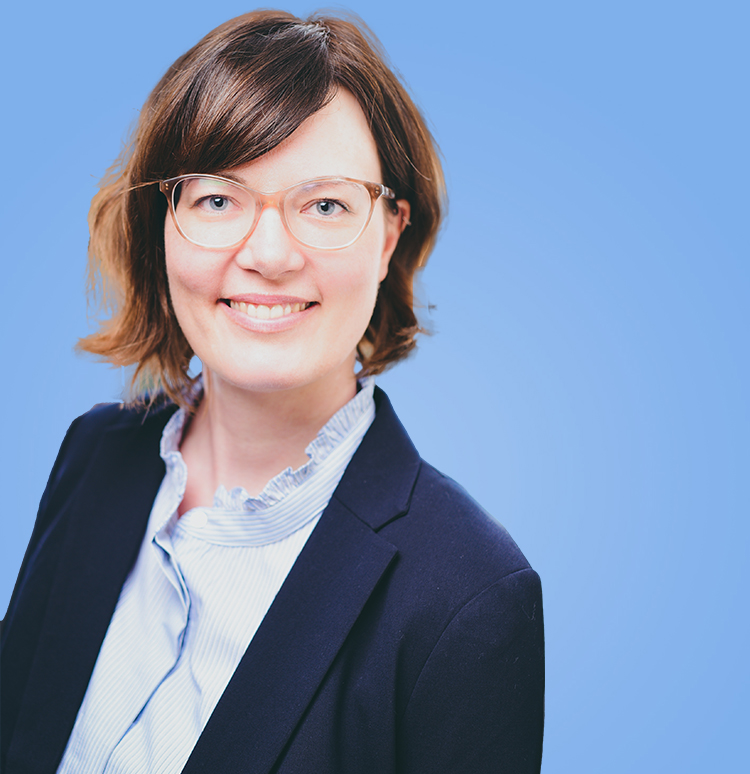 Porträt einer lächelnden Frau vor blauem Hintergrund