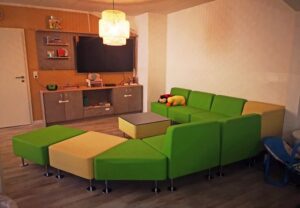 Ein gemütlich eingerichteter Raum mit farbenfrohen Möbeln und einem Fernseher