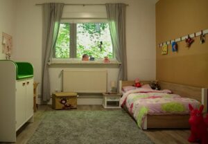 Kinderzimmer mit Bett und Spielzeug