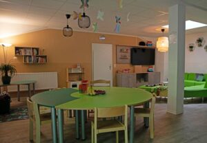 Ein Gemeinschaftsraum mit Spieltischen und bunten Stühlen