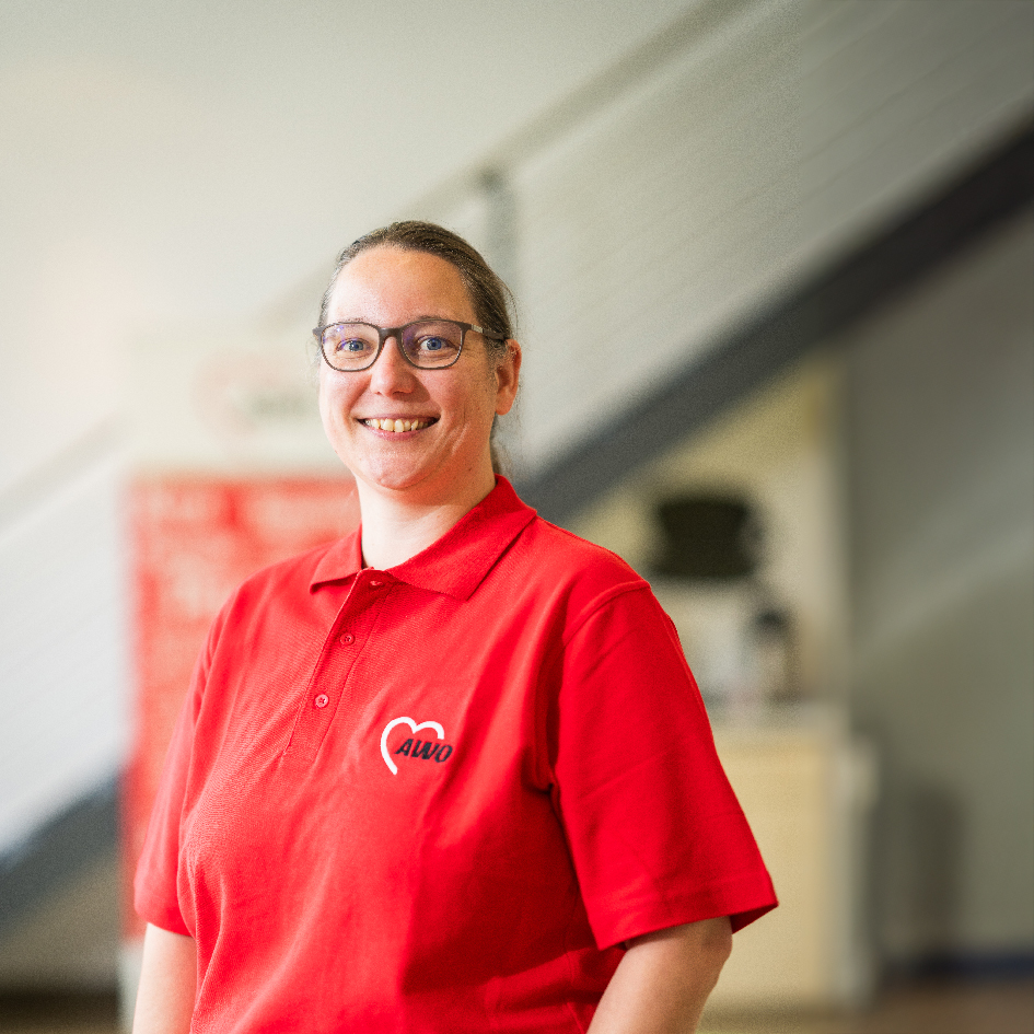 Person in rotem AWO-Poloshirt lächelt in die Kamera