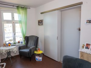 Innenansicht eines Wohnzimmers mit einem Sessel und dekorativen Elementen