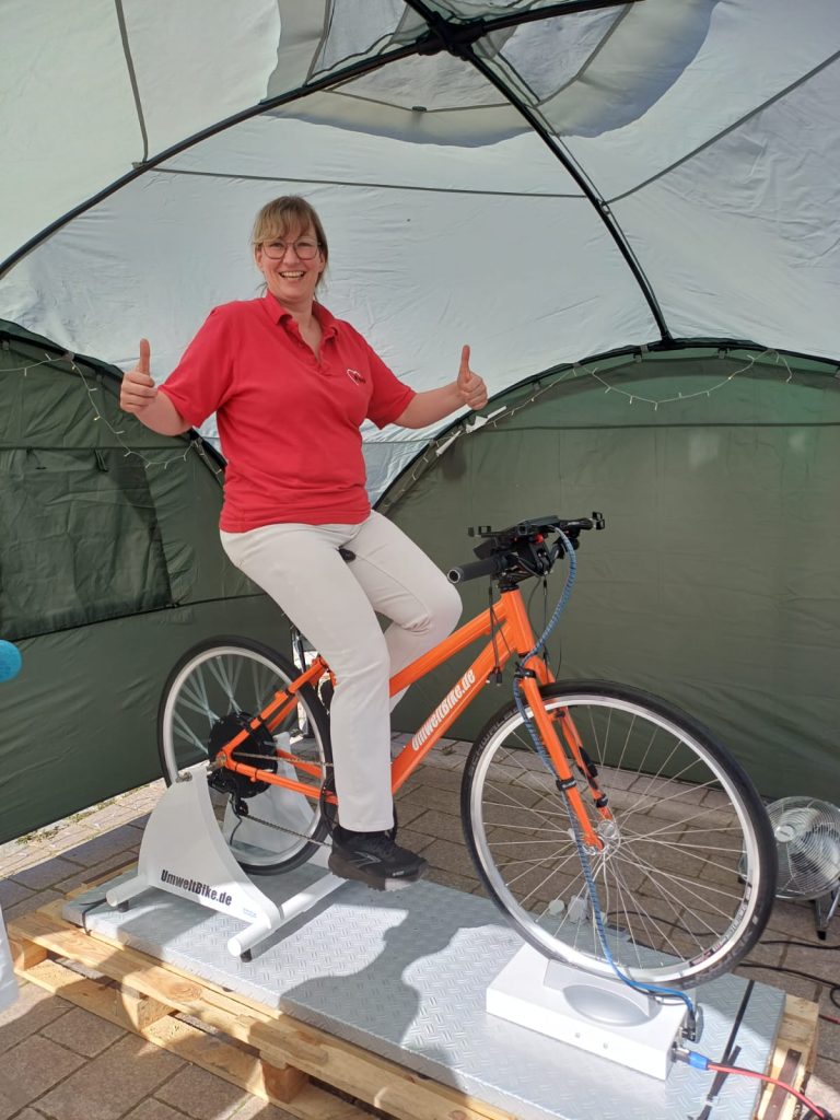 Frau auf einem feststehenden Fahrrad in einem Zelt