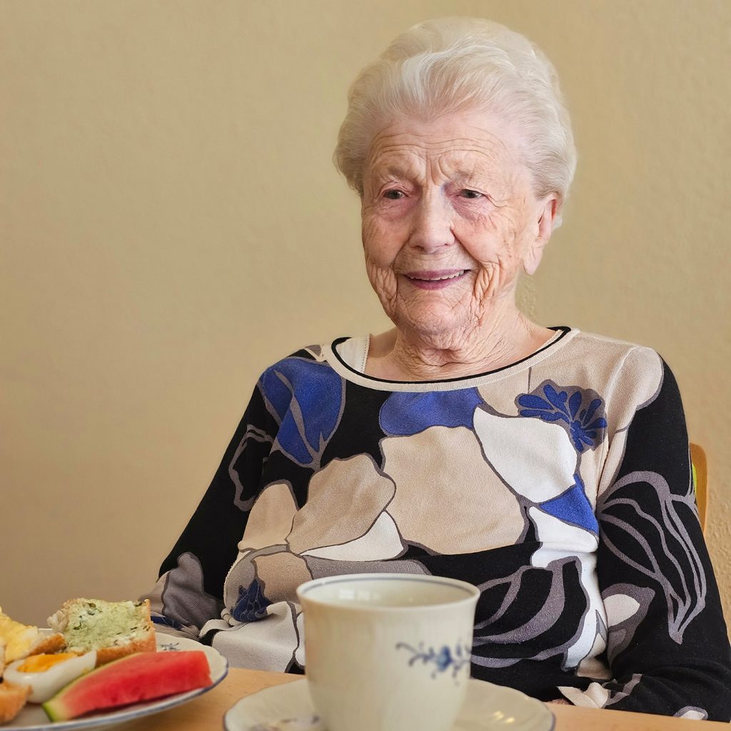 &Auml;ltere Frau am Tisch sitzend