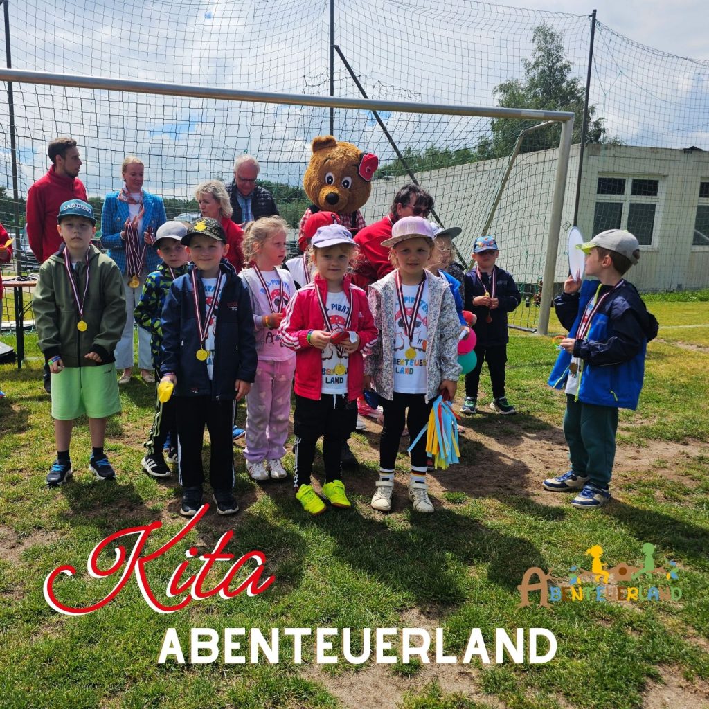 Eine Gruppe von Kindern bei einer Veranstaltung im Freien mit Medaillen um den Hals.