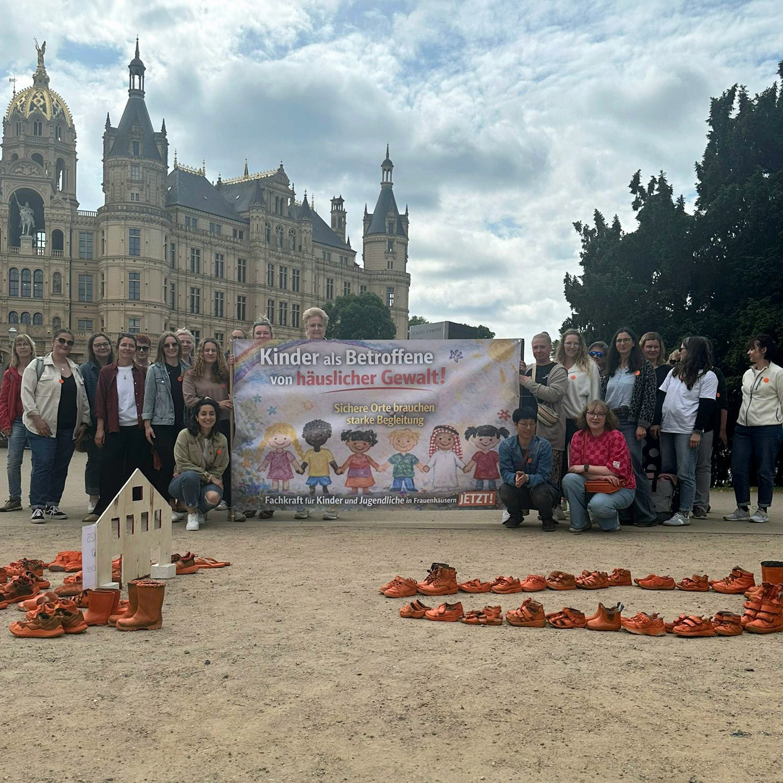 Gruppe von Menschen mit einem Banner vor einem historischen Gebäude