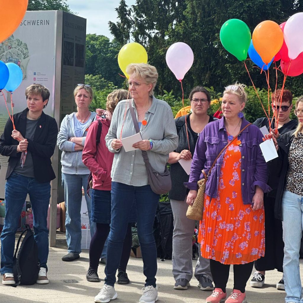 Gruppe von Menschen mit bunten Luftballons bei einer Veranstaltung