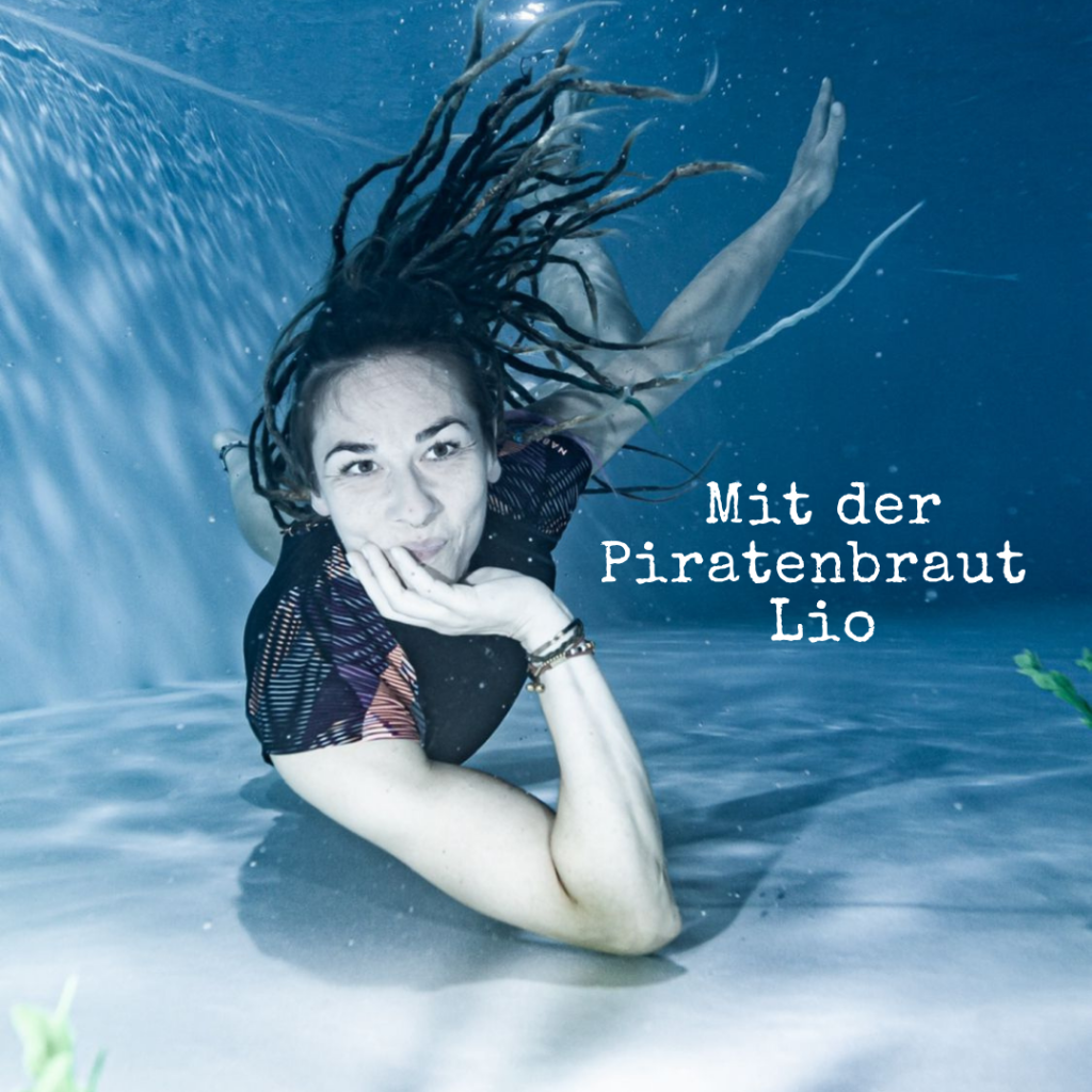 Unterwasseraufnahme einer Person mit Dreadlocks.