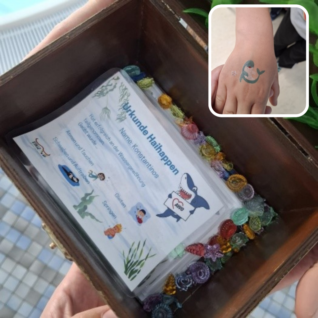 Urkunde in Schatzkiste und Hand mit Hai-Tattoo