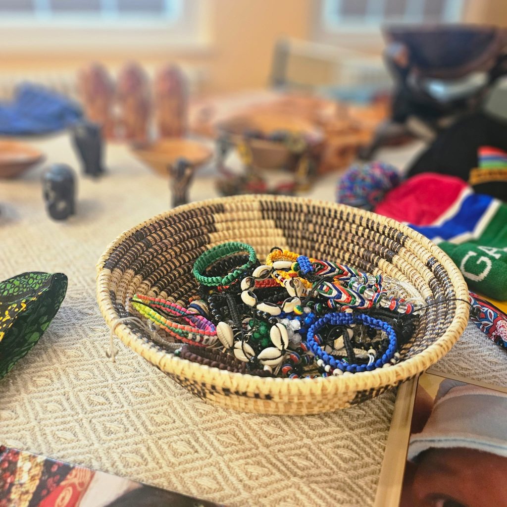Ein Korb mit handgefertigtem Schmuck auf einem Tisch mit anderen dekorativen Gegenst&auml;nden.