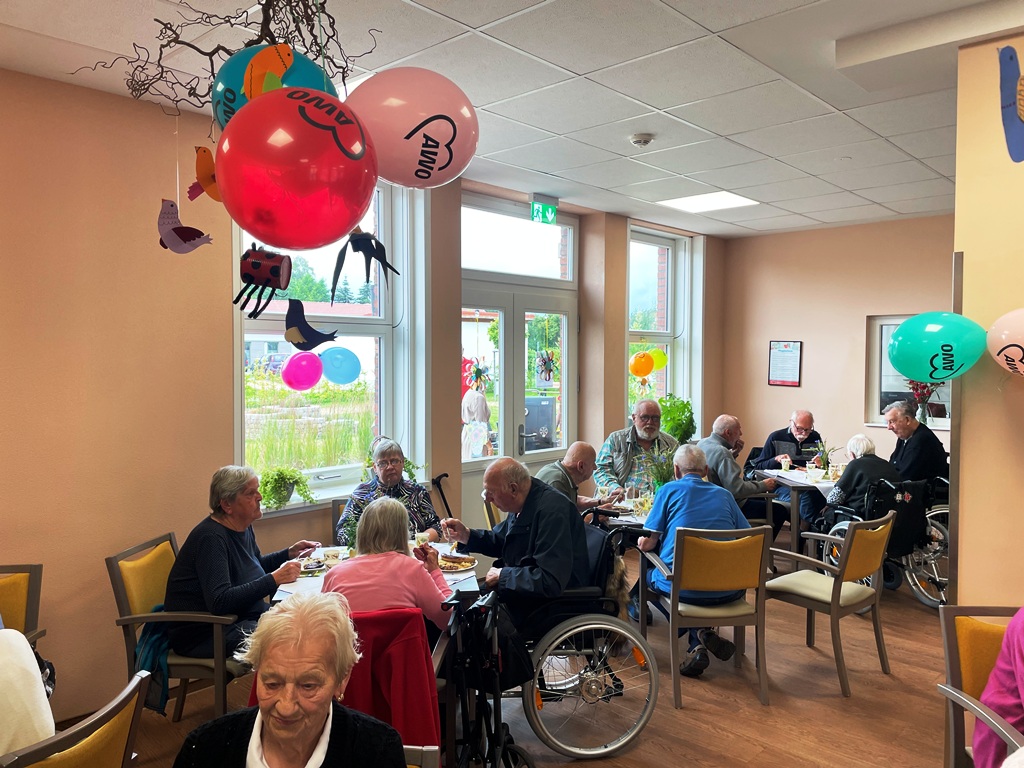 Senioren in einem Gemeinschaftsraum mit AWO-Ballons