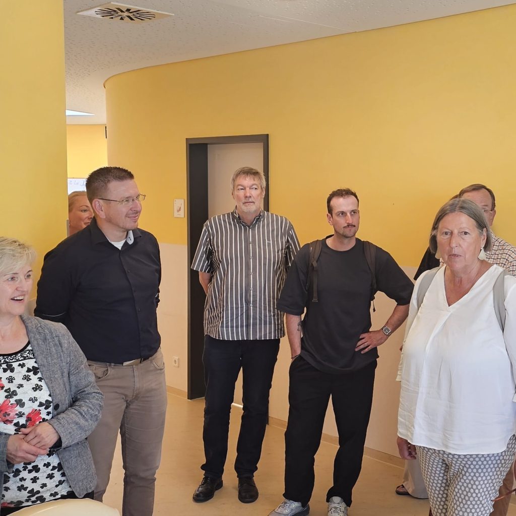 Gruppe von Menschen in einem gelben Raum.