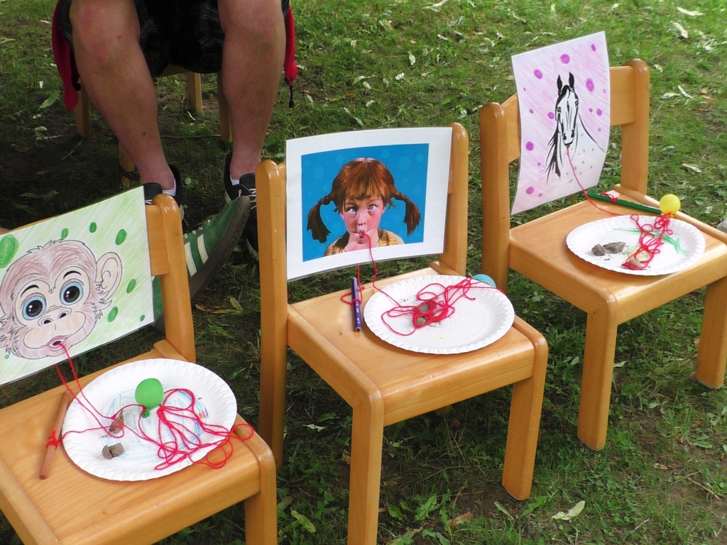 Drei Kinderstühle mit Abbildungen und Spielmaterialien