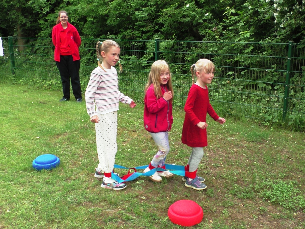Drei Kinder gemeinsam bei einem Spiel im Freien