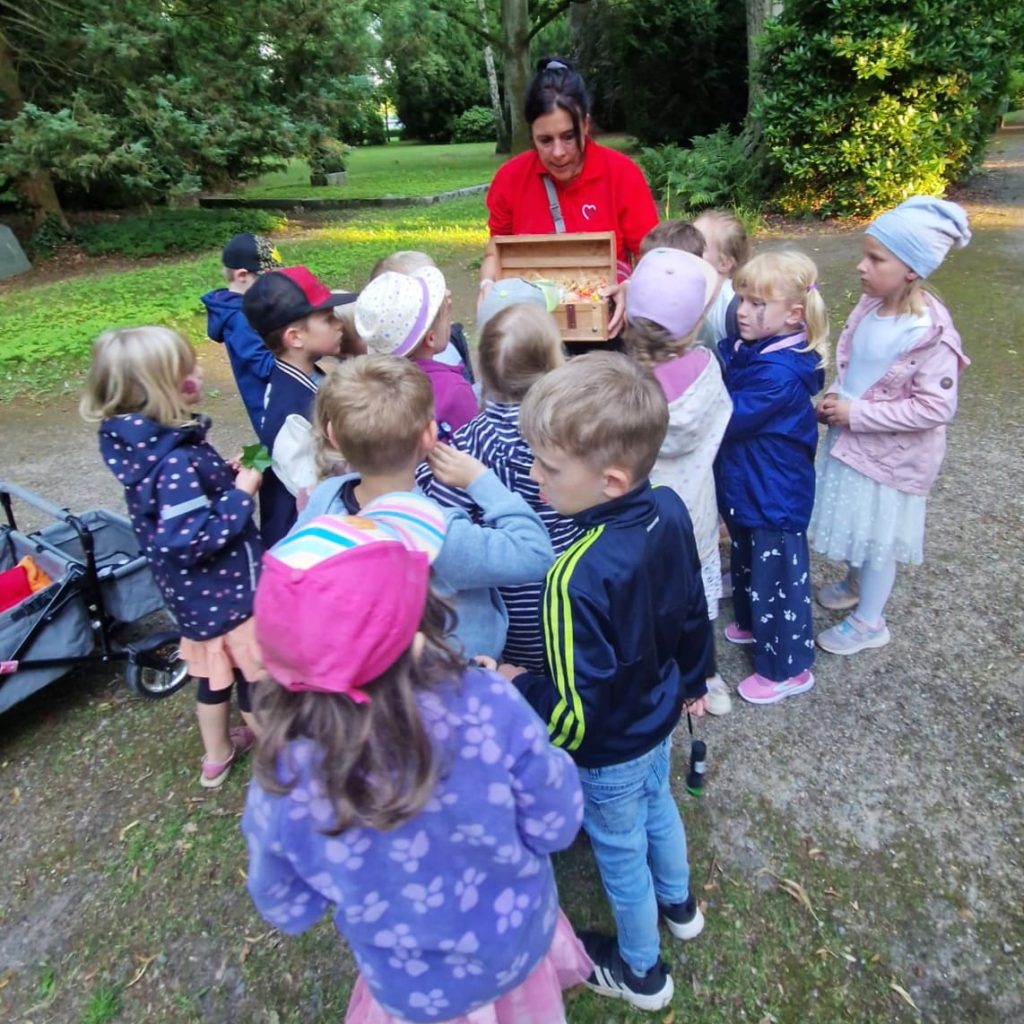 Gruppe von Kindern mit Betreuerin im Freien