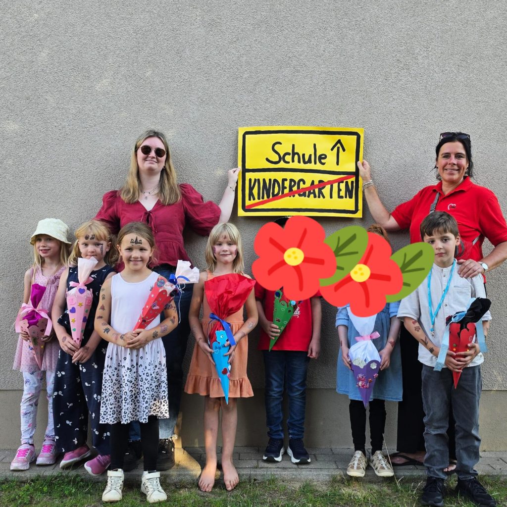 Gruppe von Kindern und zwei Erwachsenen, die ein Schild mit der Aufschrift 'Schule' halten.