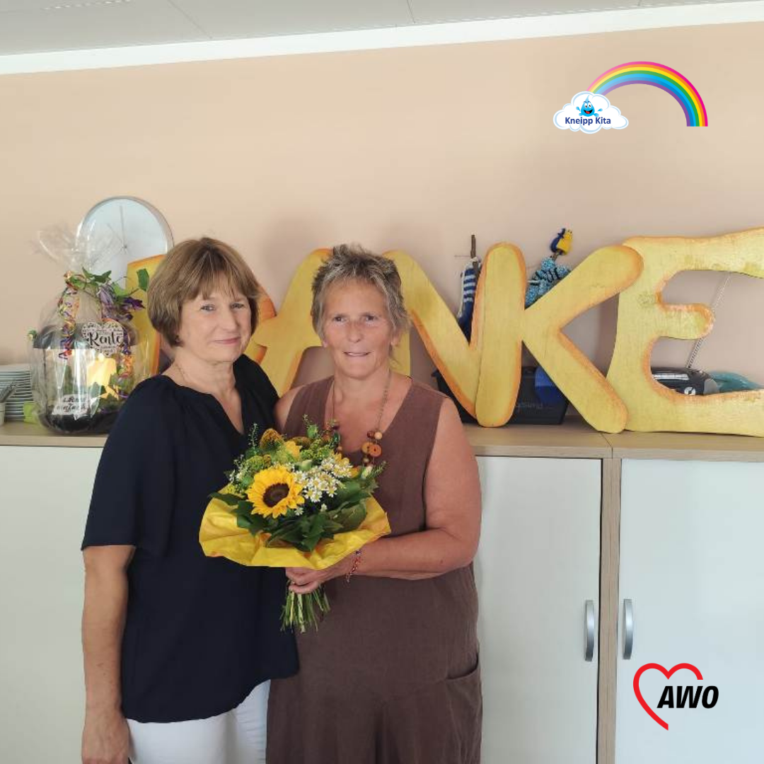 Zwei Frauen stehen vor einem Schrank. Eine hält einen Blumenstrauß. Auf dem Schrank steht groß 'Danke' geschrieben.