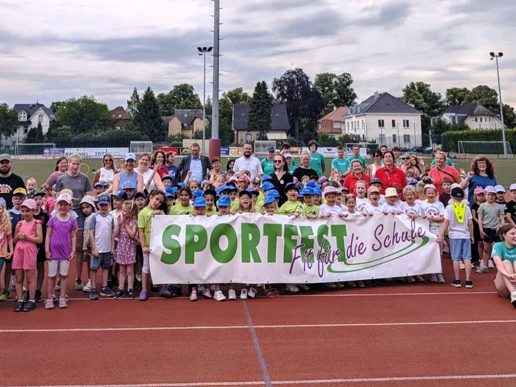 Gruppe von Menschen bei einem Sportfest auf einem Sportplatz
