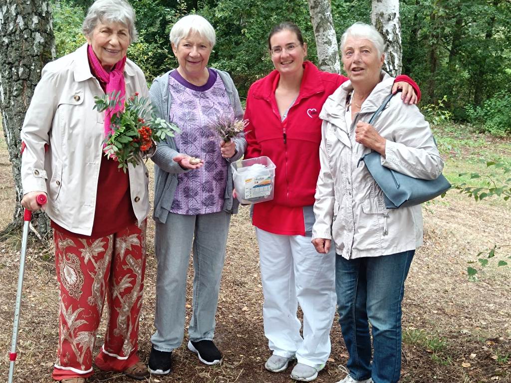 Vier Frauen stehen im Freien nebeneinander.
