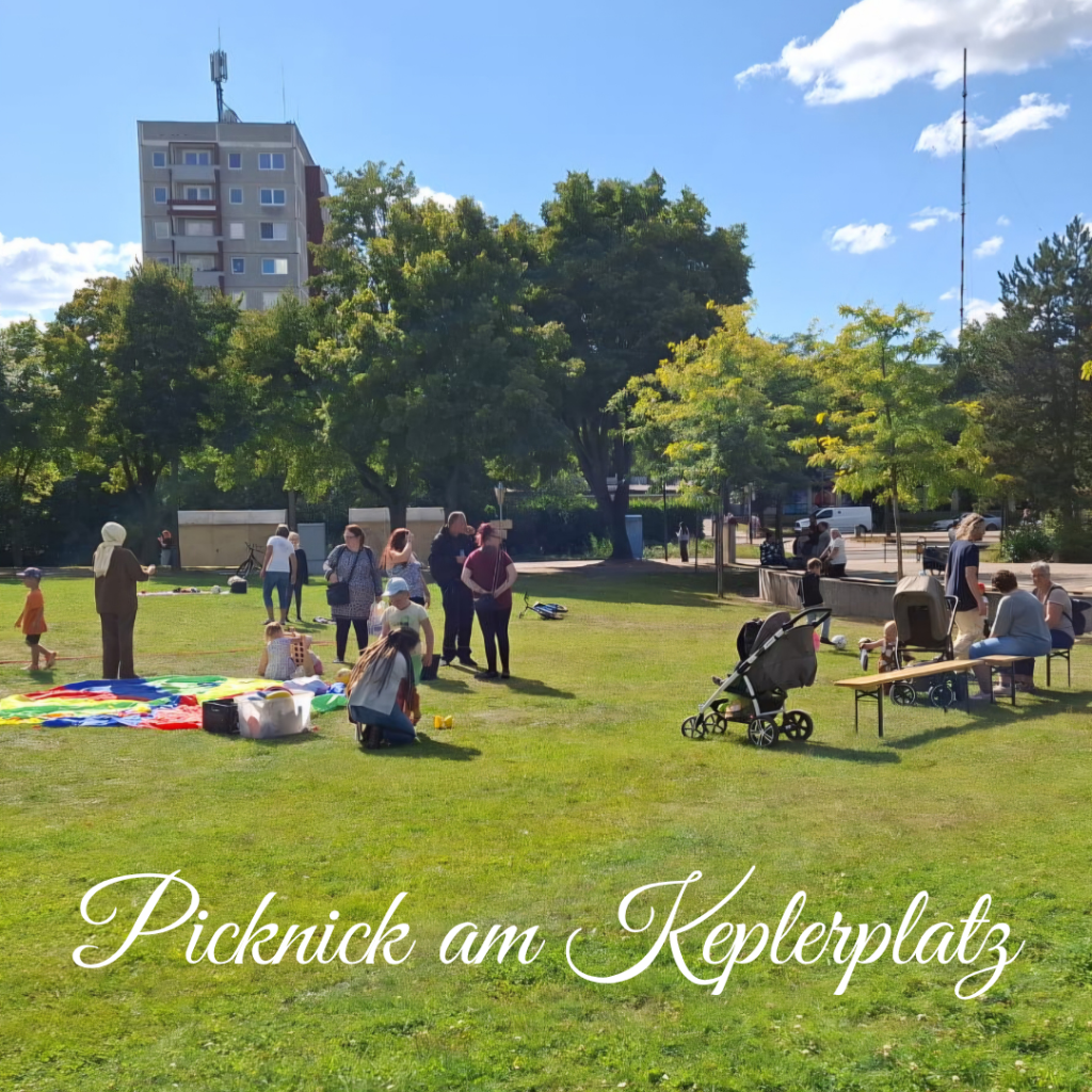 Gruppe von Menschen bei einem Picknick auf einer grünen Wiese bei sonnigem Wetter