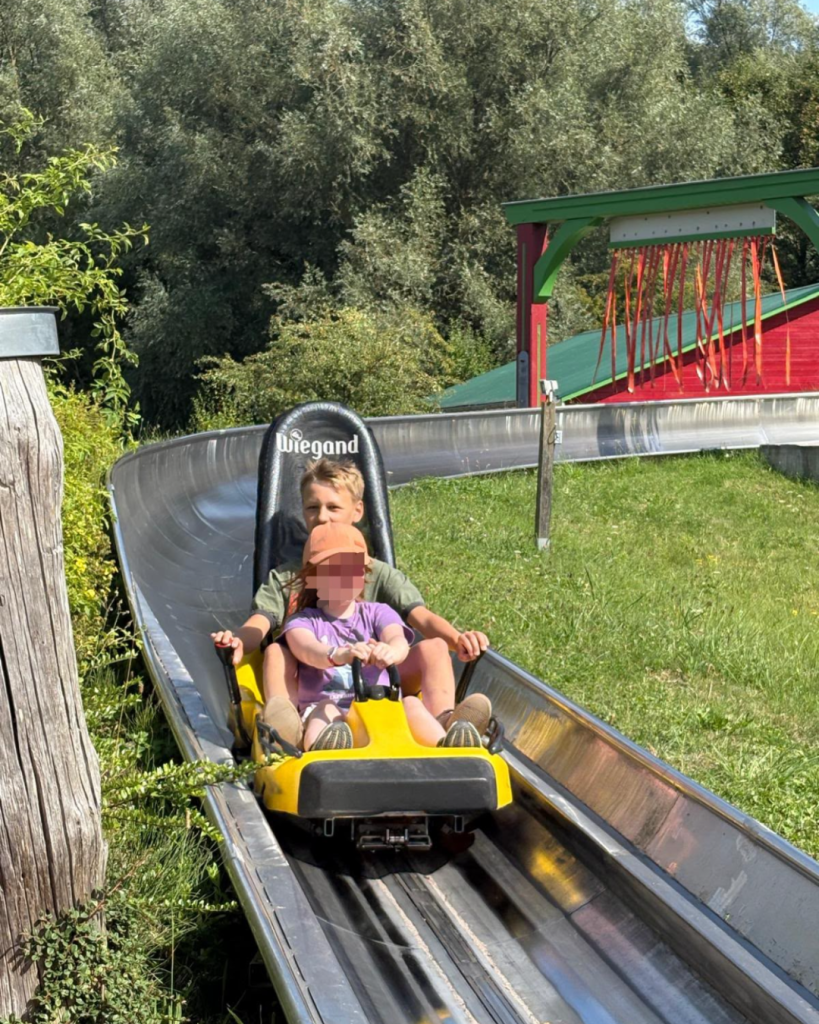 Zwei Kinder auf einer Sommerrodelbahn