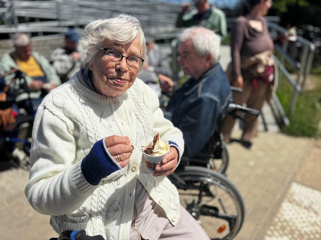 Ältere Frau isst Eis im Freien