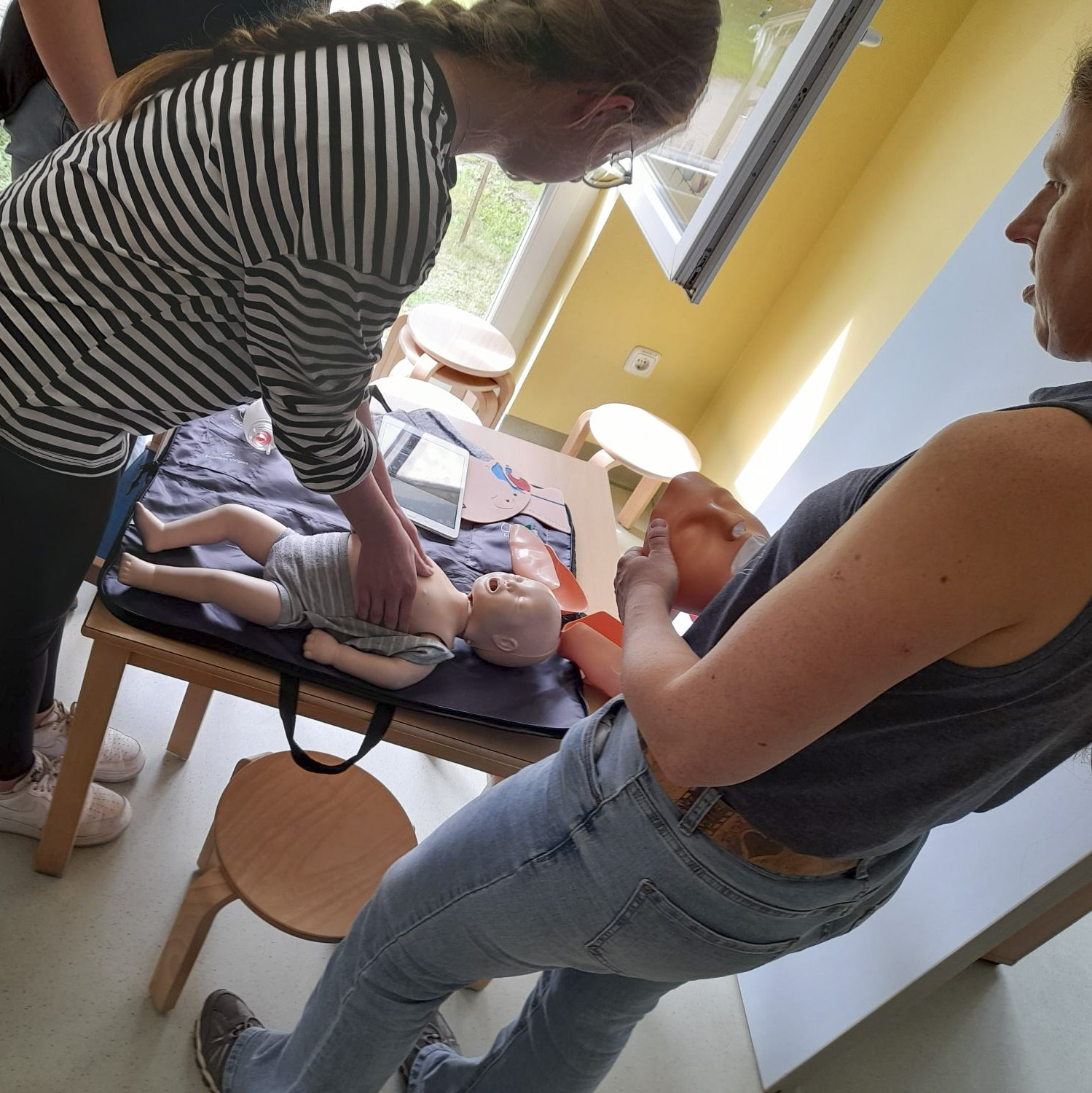 Zwei Frauen trainieren Erste Hilfe-Maßnahmen mit einer Babypuppe