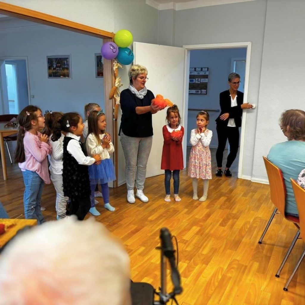 Kindergruppe und Erwachsene in einem Raum bei einer Aktivit&auml;t