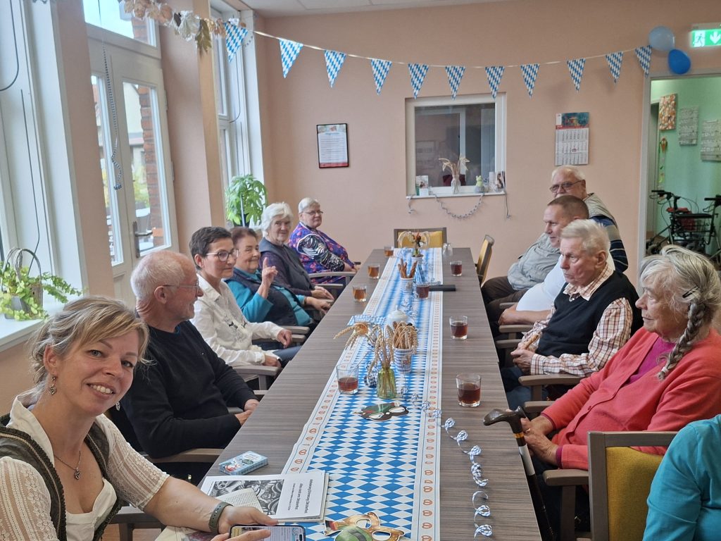 Gruppe von älteren Menschen sitzt an einem langen Tisch
