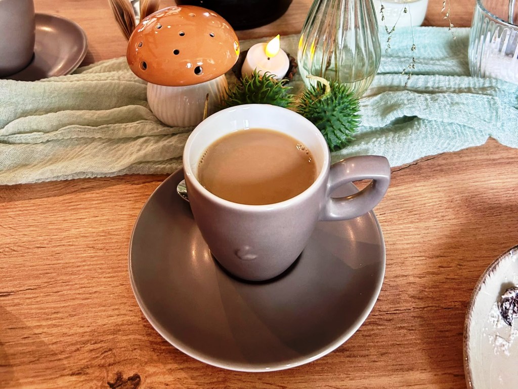Eine Tasse Kaffee auf einem gedeckten Tisch.